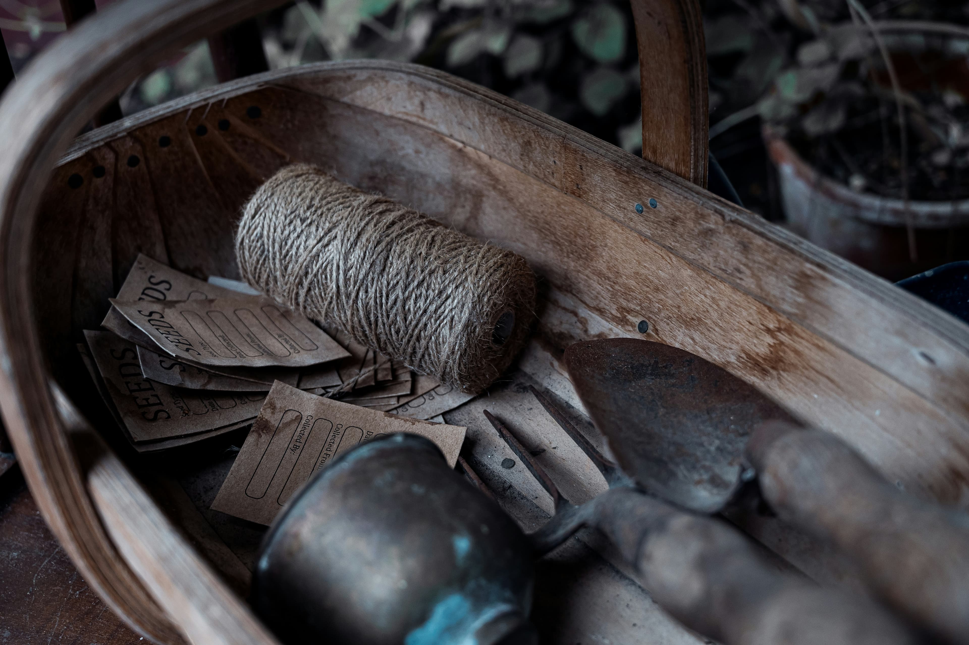 Basket of forged garden hand tools on a workshop floor